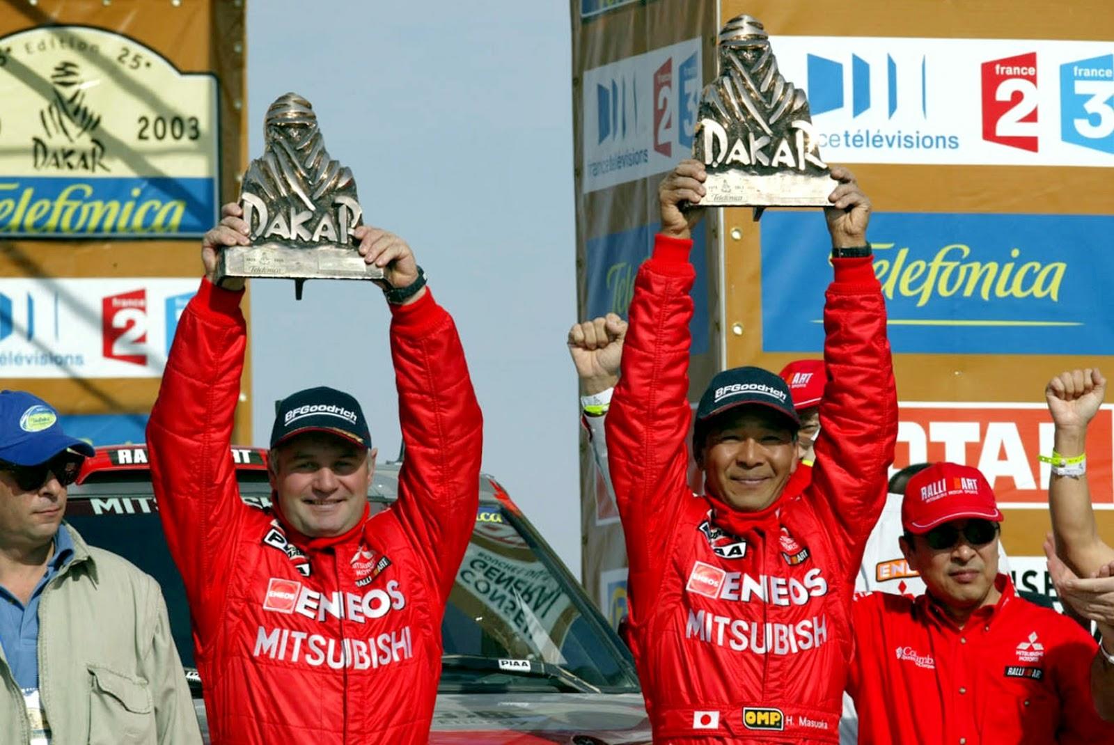 Хироси Масуока (справа). Японский раллист, автогонщик, выигравший ралли-рейд Париж — Дакар дважды: в 2002 и 2003 годах. Выступал на автомобилях Mitsubishi. Всего, с 1987 по 2009 год, провел 21 гонку в рамках «Дакара»
